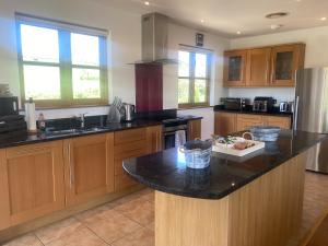 a kitchen with wooden cabinets and a black counter top at Whitehall Farm in Caerleon
