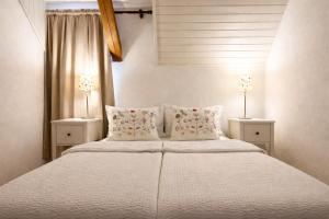 a bedroom with a large white bed with two lamps at Rose Cottage in Bovec