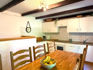 a kitchen with a table with a bowl of fruit on it at Rose Cottage in Bovec +12 photos