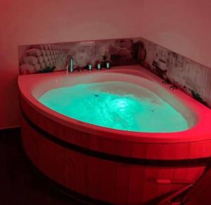 a hot tub with a red lighting in a bathroom at Jacuzzi Loft in the Center of Riga in Riga