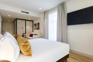 a bedroom with a large white bed and a couch at Casa Falcão Boutique Hotel by Aspasios in Porto