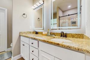 a bathroom with two sinks and a large mirror at 2 Mi to Beach! Group-Friendly Navarre Getaway in Navarre +24 photos