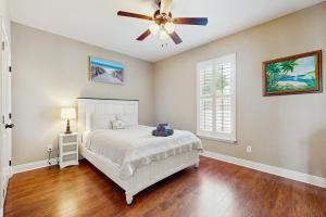 a bedroom with a bed and a ceiling fan at 2 Mi to Beach! Group-Friendly Navarre Getaway in Navarre