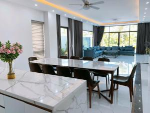 a dining room and living room with a table and chairs at FLC Grand Villa BT31-26 in Sầm Sơn