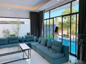 a woman standing in a living room looking out the window at FLC Grand Villa BT31-26 in Sầm Sơn