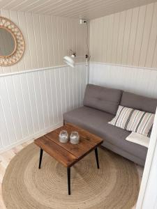 a living room with a couch and a coffee table at Cozy summer cottage in Hasmark in Otterup
