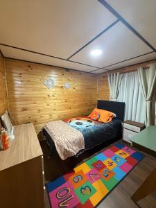 a bedroom with a bed and a colorful rug at Cabaña de campo in Castro