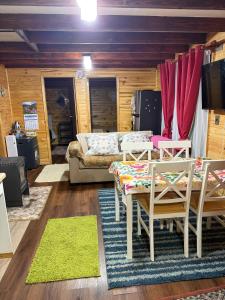 a living room with a couch and a table and chairs at Cabaña de campo in Castro