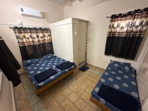 a small room with two beds and a window at Rudraksh Homestay in Dwarka