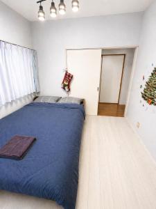 a bedroom with a blue bed with a christmas tree at 75m2 10people private house rental 8beds 8min Ikebukuro 13min Shinjuku 18min Shibuya Englishspeaking staff available in Tokyo