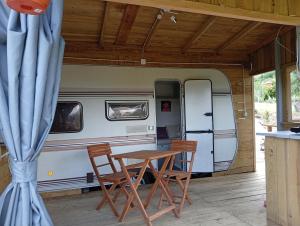 a table and two chairs in front of a caravan at Cabana do Gipsy in Ponte da Barca