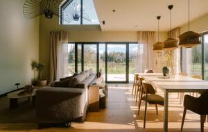 a living room with a couch and a table with chairs at Wolne Domy in Dominikowice
