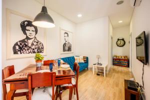 a dining room with a table and a blue couch at Casa Da Avo Clementina in Funchal