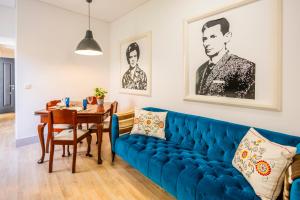 a living room with a blue couch and a table at Casa Da Avo Clementina in Funchal