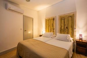 a bedroom with a large white bed and two windows at Casa Da Avo Clementina in Funchal