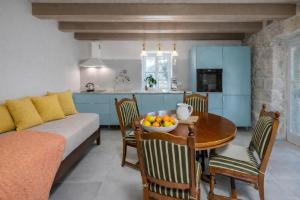 a kitchen and dining room with a table and a couch at Deluxe Nature Resort Galovi Dvori in Rab