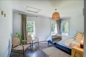 a bedroom with a bed and two windows at Käbane Kozya - La Rassembleuse in Les Éboulements +15 photos