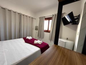 a bedroom with a bed with two towels on it at Pousada Villa Galinhos in Galinhos