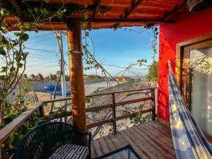 a porch with a hammock and a view of the beach at Pousada Villa Galinhos in Galinhos