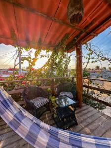 a patio with chairs and a table on a deck at Pousada Villa Galinhos in Galinhos