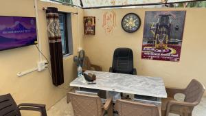 a room with a table and chairs and a clock at Rudraksh Homestay in Dwarka