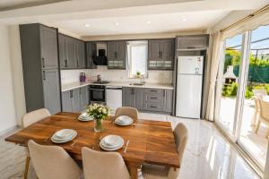 a kitchen with a wooden table and chairs at Villa Maya in Ortaca