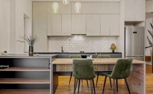 a kitchen with a wooden table and green chairs at Apartment with Exclusive Amenities in George Town +23 photos