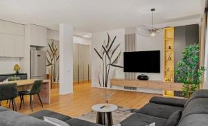 a living room with a couch and a tv on a wall at Apartment with Exclusive Amenities in George Town