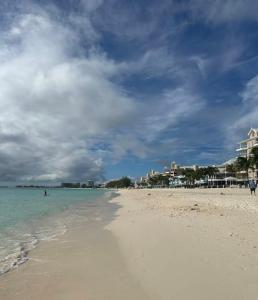 a beach with people in the water and buildings at Apartment with Exclusive Amenities in George Town