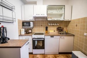 a kitchen with white cabinets and a stove top oven at MA-LO 1 in Pirovac