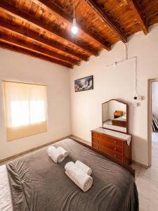 a bedroom with a bed with two towels on it at Peyia traditional house in Paphos