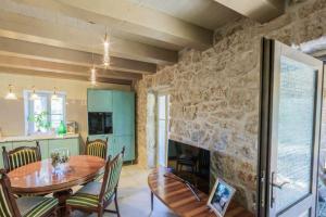 a dining room with a table and a stone wall at Deluxe Nature Resort Galovi Dvori in Rab