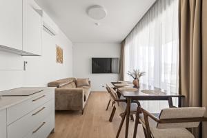 a kitchen and living room with a table and chairs at Dunique Summer in Palanga