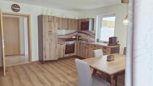 a kitchen with a wooden table and a dining room at Konis Ferienwohnung - barrierearm in Rangersdorf