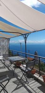 a table on a balcony with a view of the ocean at Venti In Costa in Furore