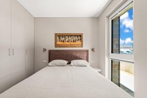 a bedroom with a large bed and a window at Dunique Summer in Palanga