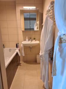 a bathroom with a sink and a toilet and a tub at Aqua Apartman Panoráma in Velence +16 photos