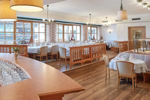 a restaurant with tables and chairs and windows at Hotel Sonnenhügel, inklusive SommerCard in Filzmoos