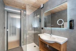 a bathroom with a sink and a shower at Hotel Sonnenspitz *** in Kochel +79 photos