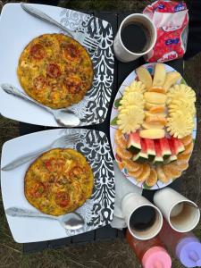 a table with three plates of food and cups of coffee at Diva sunset garden in Senaru