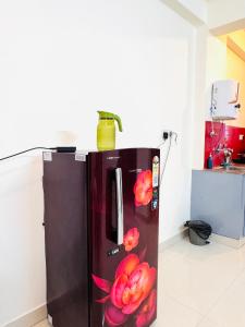 a black refrigerator with flowers painted on it in a kitchen at Gachi Ghar Gachibowli 2 BHK in Hyderabad