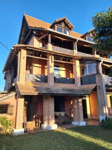 a large brick house with a balcony on the front at Hotel Anjara in Ambositra
