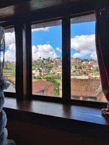 a window with a view of a city at Hotel Anjara in Ambositra +1 photo
