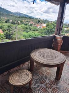 a table and two stools on a balcony with a view at Hotel Anjara in Ambositra
