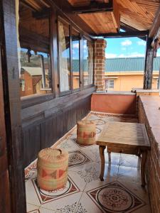 a porch with a table and two barrels on it at Hotel Anjara in Ambositra