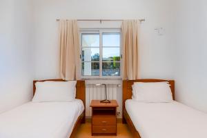 two beds in a room with a window at Vila Fantastica in Aljezur