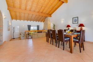 a dining room with a wooden table and chairs at Vila Fantastica in Aljezur