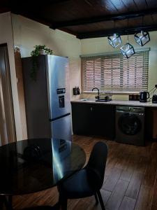 a kitchen with a table and a stainless steel refrigerator at Grey Falcon Ridge in Albinia