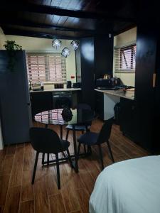 a room with a table and chairs and a kitchen at Grey Falcon Ridge in Albinia