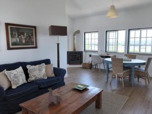 a living room with a blue couch and a table at Pátio das Ribeiras in Almeirim